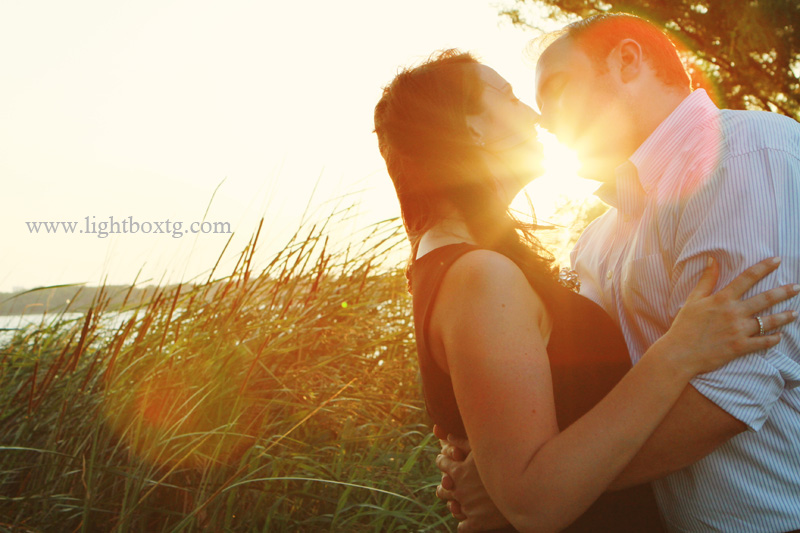 couple kissing sunset. behind kissing couple