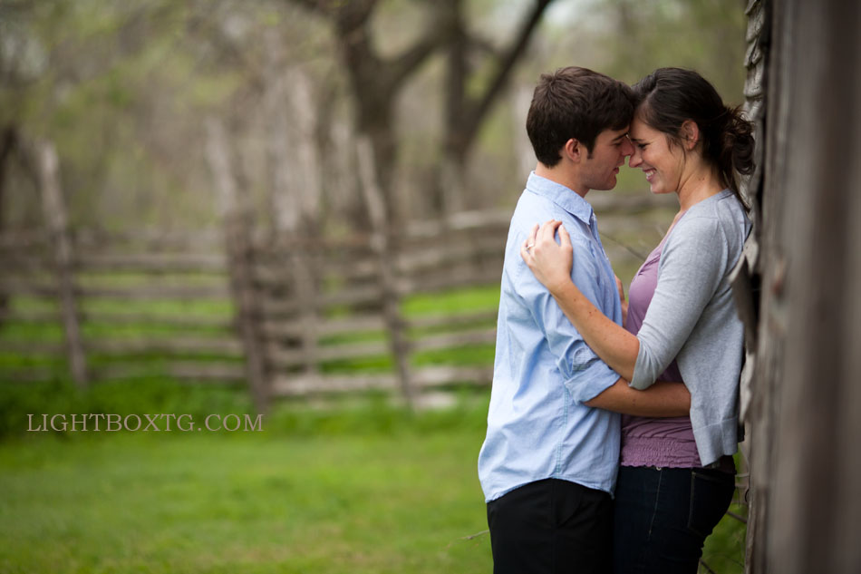 couple photo of man and woman smiling and laughing outside at a barn in Cedar Hill State Park